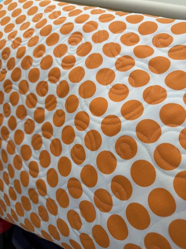 Swirl stitch on orange polka dot quilt