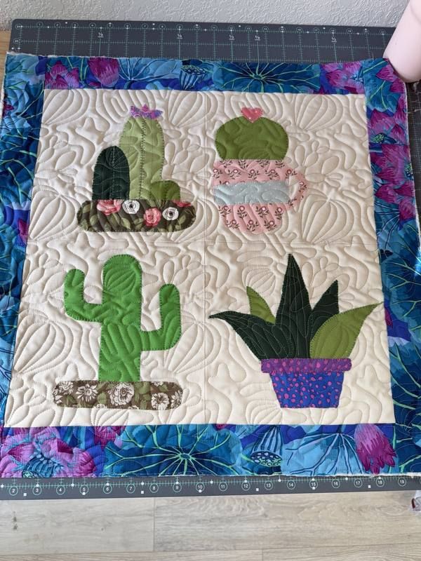 Cactus appliqué mini quilt with floral border